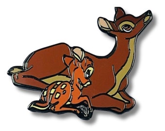 Puede incluir: Un pin de esmalte que representa a Bambi y su madre, un personaje clásico de Disney, en una pose juguetona. El pin es de color marrón y beige.