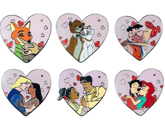 May include: Six pink heart-shaped pins with different cartoon couples. The couples include a fox and rabbit, two cats, a man and woman, a man and woman with a crown, a man and woman with a dog, and a man and woman with a mermaid tail.