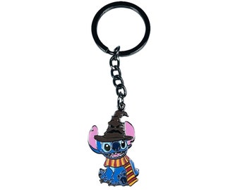 May include: A blue Stitch character wearing a brown wizard hat and a red and yellow scarf, attached to a black metal keychain.