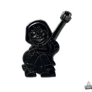May include: Black and white enamel pin featuring a cartoon character with a guitar. The character is wearing a hooded jacket and has a skull-like face.