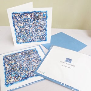 Könnte beinhalten: Grußkarten mit einer Aquarellillustration einer Menschenmenge in Blau und Weiß. Die Karten haben einen blauen Rand und werden von blauen Umschlägen begleitet. Der Text "At The Match EFC" ist auf einer Karte zu sehen.