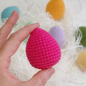 May include: A bright pink crocheted Easter egg. The egg is made with a textured stitch and is a popular craft project.