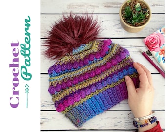 May include: A colorful crocheted hat with a burgundy pom pom. The hat has stripes of blue, purple, green, and pink yarn.