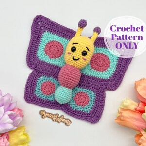 May include: Crochet pattern for a purple and green butterfly with a yellow smiling face. The text "Crochet Pattern ONLY" is in a white circle.