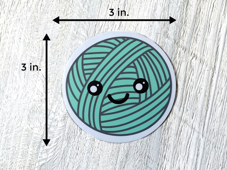 May include: A 3-inch round sticker featuring a green yarn ball with a smiling face. The yarn ball has a white outline and black eyes.
