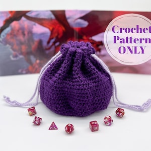 Puede incluir: Bolsa de dados de crochet morado con cierre de cord&oacute;n. La bolsa est&aacute; llena de dados coloridos. Patr&oacute;n de crochet solamente.