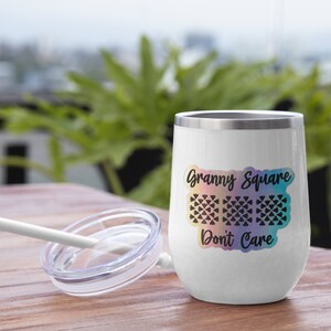 May include: White stainless steel tumbler with a rainbow gradient design and the text "Granny Square Don't Care". The tumbler has a black and white graphic of a granny square crochet pattern.