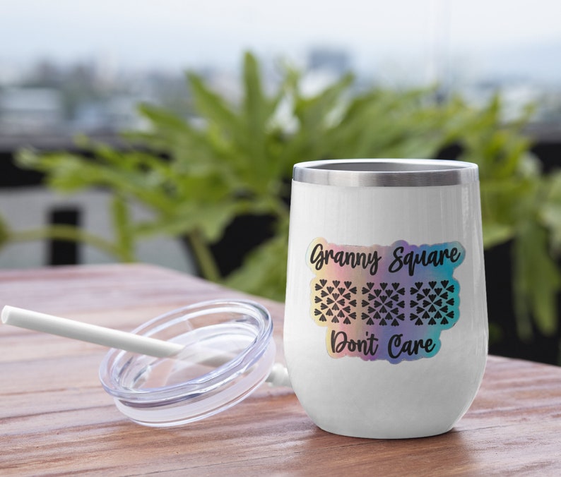 May include: White stainless steel tumbler with a rainbow gradient design and the text "Granny Square Don't Care". The tumbler has a black and white graphic of a granny square crochet pattern.