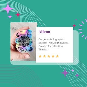 May include: A holographic sticker featuring a pair of hands holding a ball of yarn with a star and crescent moon design. The sticker has a rainbow iridescent finish. The text "Green Fox Farms Designs" is visible in the background.