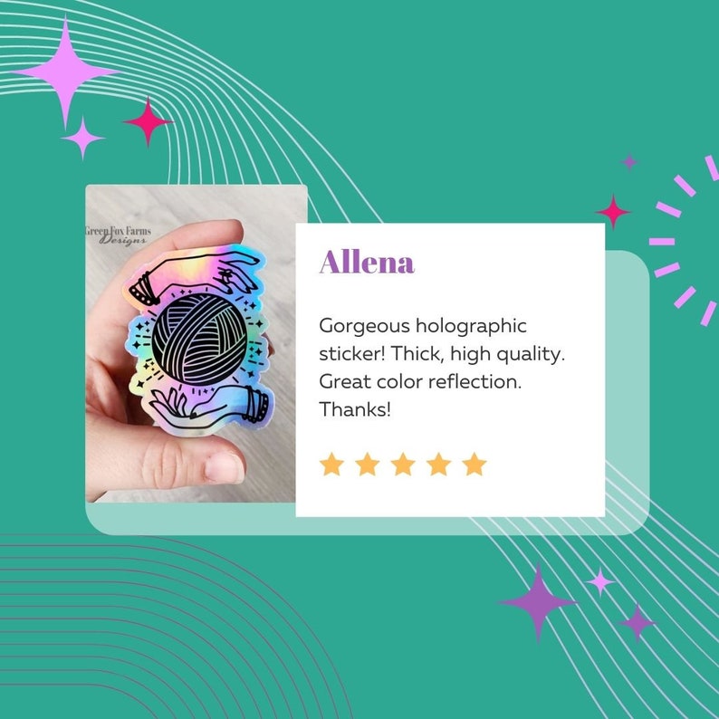 May include: A holographic sticker featuring a pair of hands holding a ball of yarn with a star and crescent moon design. The sticker has a rainbow iridescent finish. The text "Green Fox Farms Designs" is visible in the background.