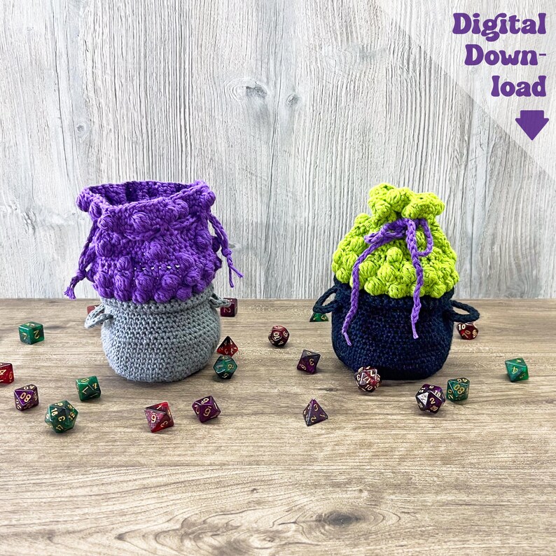 May include: Two handmade crochet dice bags in purple, gray, and green, with a scattering of colorful dice on a wooden surface. One bag is purple and gray, the other is green and navy blue. The text "Digital Download" is visible.