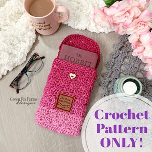May include: Crochet pattern for a book sleeve in pink and red yarn. The sleeve is designed to fit a book titled "The Hobbit". The pattern is available for purchase.