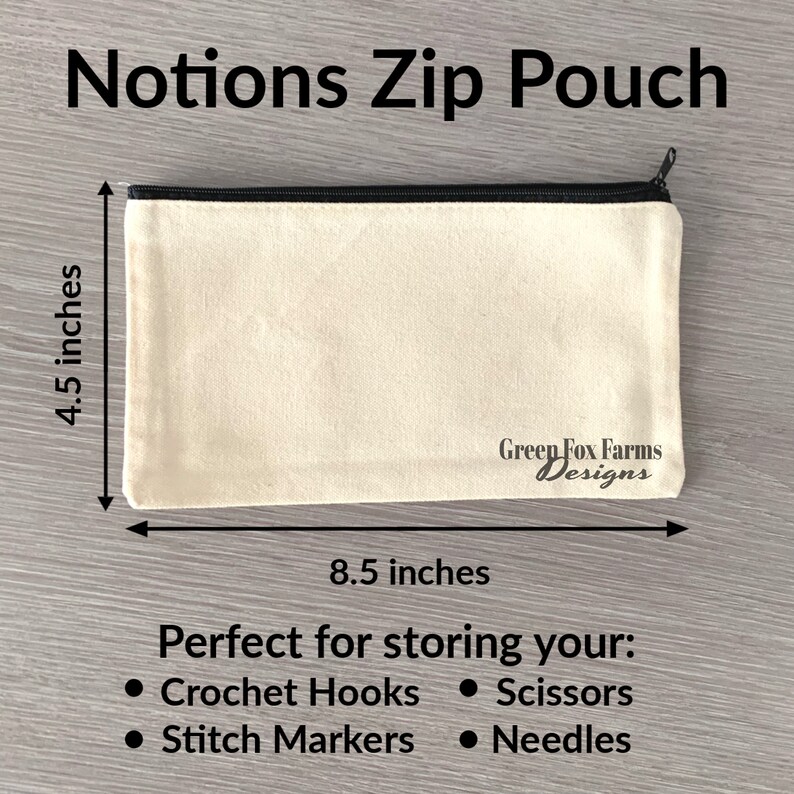 May include: A beige canvas zip pouch with a black zipper and black trim. The pouch measures 8.5 inches by 4.5 inches and has the text "Green Fox Farms Designs" printed on the bottom. The pouch is perfect for storing crochet hooks, scissors, stitch markers, and needles.