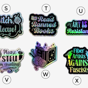 May include: Set of 8 iridescent holographic stickers with various slogans related to art, reading, and fiber arts. The stickers feature slogans such as "Stitch Please!" "Read Banned Books" "Art is Resistance" "Please STFU I'm counting!" "Fiber Artists Against Fascists".