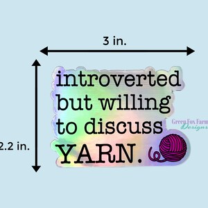 May include: A holographic sticker with the text "introverted but willing to discuss YARN." and a pink yarn ball. The sticker is 3 inches wide and 2.2 inches tall.