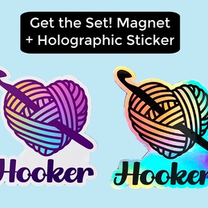 May include: A set of two stickers featuring a heart-shaped ball of yarn with a crochet hook. One sticker is a regular sticker, and the other is a holographic sticker. Both stickers have the word "Hooker" printed below the yarn ball.
