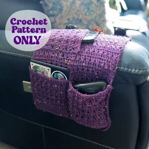 May include: Purple crocheted couch armrest organizer with pockets for remotes, phones, and other small items. "Crochet Pattern ONLY" is written in a circle on the image.