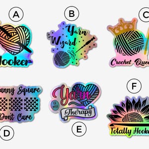 May include: Set of 6 iridescent vinyl stickers with various crochet and yarn themed designs. The stickers feature text such as "Yarn Wizard", "Hooker", "Crochet Queen", "Granny Square Don't Care", "Yarn is My Therapy", and "Totally Hooked".