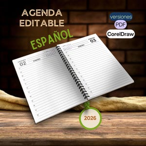 May include: A white, spiral bound, 2026 agenda book with the words "AGENDA EDITABLE ESPAÑOL" in black text on the front cover. The book is open to January, with the dates 02 and 03 visible. The book is sitting on a wooden surface with a green and beige tag that says "2026" hanging from the bottom.