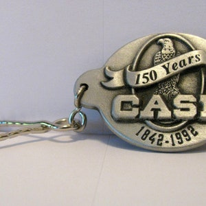 J I Case Corporation 150e anniversaire mettant en vedette le vieux pygargue à tête blanche Abe perché sur un porte-clés du logo de marque Globe Émis en 1992 Collectible