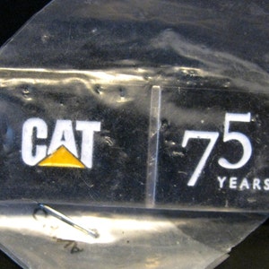 May include: A black and yellow CAT logo with the text "75 YEARS" on a black background.