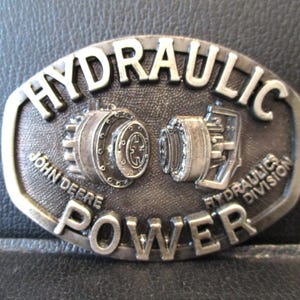 John Deere Hydraulics Division Waterloo Iowa Hydraulic Power Pump Metal Belt Buckle 1985 Spec Cast Rockford IL jd Collectible