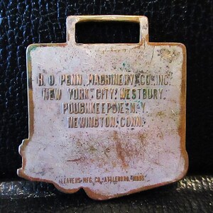 May include: A brass key chain with the text "H.O. PENN, MACHINERY CO. INC. NEW YORK CITY: WESTBURY. POUGHKEEPSIE, N.Y. NEWINGTON, CONN. LEAVENS MFG. CO. ATLEBORO, MASS."