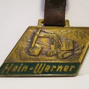 Hein Werner Corporation Waukesha WI Crawlers Carriers Hydraulic Excavators & Cranes Brass Pocket Watch Fob Construction Advertising Promo