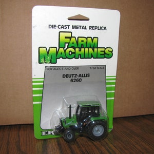 May include: A green and black Deutz-Allis 6260 tractor die-cast metal replica toy in a plastic blister pack. The packaging features the words "Farm Machines" and "1/64 Scale".