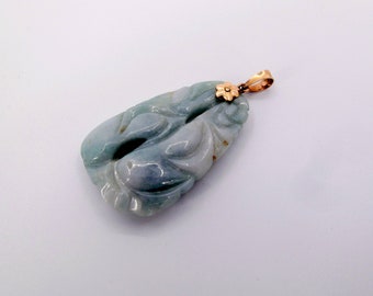 May include: A carved jade pendant with a gold flower accent. The pendant is a light green color and has a delicate, intricate design.