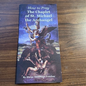 May include: A book titled "How to Pray The Chaplet of St. Michael the Archangel" by Marge Steinhage Fenelon. The cover features a painting of the Archangel Michael defeating a demon.