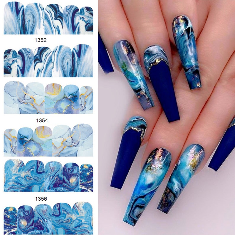May include: Blue and gold marble nail art stickers. The stickers feature a swirling blue and gold marble design. The stickers are shown on a set of long, blue painted nails.