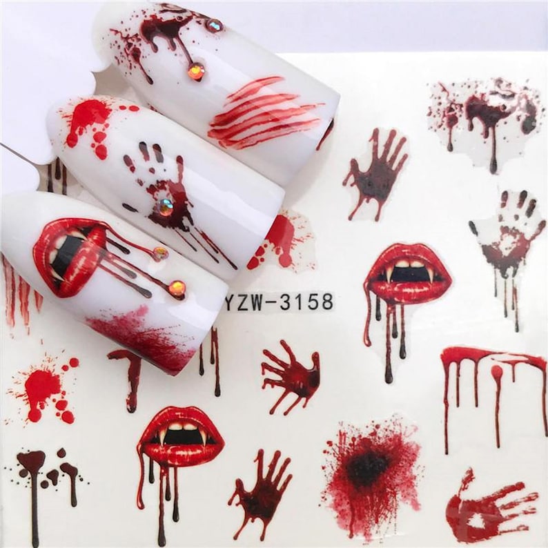 Puede incluir: Una hoja de pegatinas para u&ntilde;as con tem&aacute;tica de Halloween. Las pegatinas presentan im&aacute;genes de sangre goteando, huellas de manos ensangrentadas y colmillos de vampiro. El texto "YZW-3158" est&aacute; impreso en la hoja.