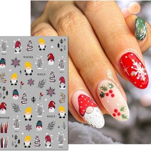 May include: A sheet of nail stickers with a winter theme. The stickers feature gnomes, snowflakes, trees, and the words "Winter Nails".