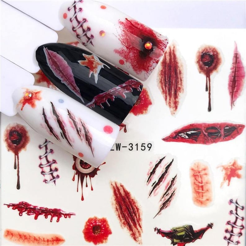 Puede incluir: Una hoja de pegatinas para u&ntilde;as con una variedad de dise&ntilde;os sangrientos y sangrientos, incluyendo puntos de sutura, marcas de garras y sangre goteando. Las pegatinas est&aacute;n sobre un fondo blanco y son perfectas para crear un look de Halloween espeluznante.