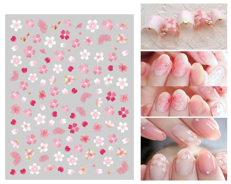 May include: Pink and white nail stickers with cherry blossom designs. The stickers feature a variety of cherry blossoms, petals, and hearts.