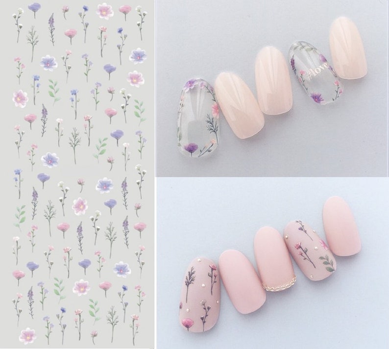 Puede incluir: Pegatinas de arte de u&ntilde;as con un dise&ntilde;o floral. Las pegatinas presentan peque&ntilde;as flores delicadas en tonos de rosa, morado y azul, con tallos y hojas verdes. Las pegatinas se muestran en una hoja y se aplican a un conjunto de cinco u&ntilde;as de color nude.