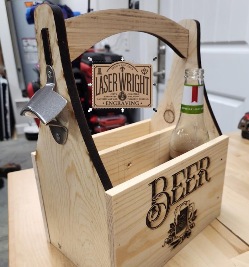Puede incluir: Un portabotellas de cerveza de madera con un abridor de botellas incorporado. El portabotellas tiene un asa y est&aacute; dise&ntilde;ado para contener varias botellas. La palabra "BEER" est&aacute; grabada en la parte delantera, junto con un emblema decorativo. El portabotellas tambi&eacute;n presenta el texto "LASER WRIGHT ENGRAVING".