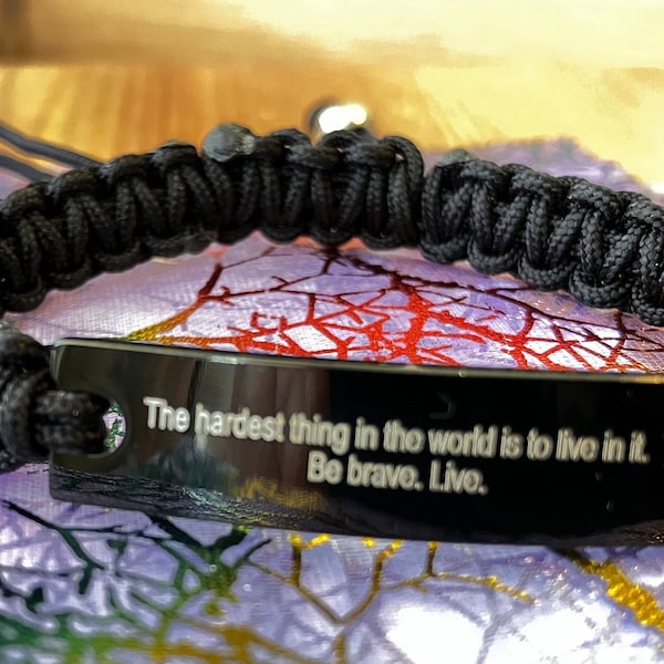 Bracelet with “Buffy" quote. The bracelet is adjustable, all in black except for the quote.