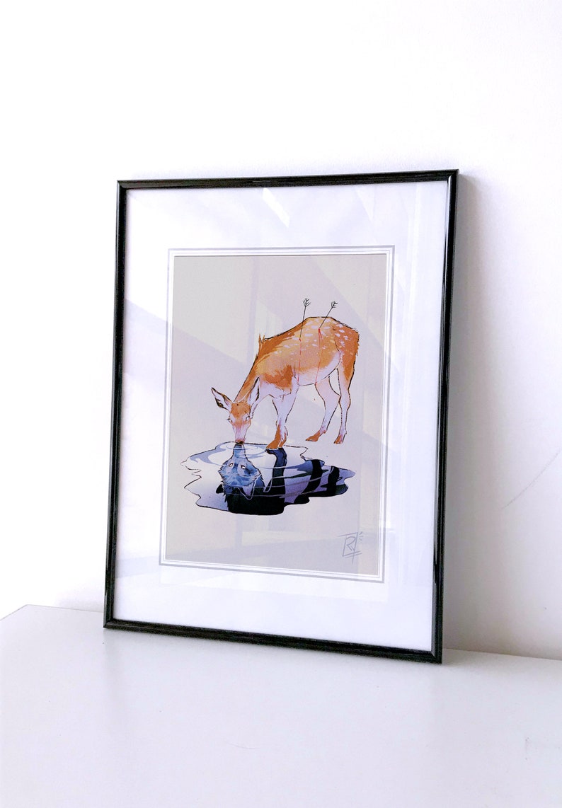 May include: Framed art print featuring a watercolor illustration of a deer drinking from a pool of water. The deer is depicted in shades of brown and orange, with arrows in its back. The water reflects a distorted image of a figure.