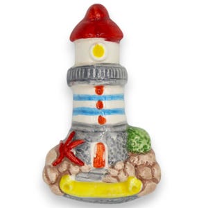 May include: A ceramic lighthouse figurine with a red roof, white body, and blue stripes. The base features a starfish, a green bush, and a yellow banner. The lighthouse has a small orange door and a yellow light.