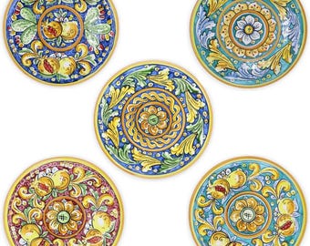 Può includere: Cinque piatti decorativi in ceramica con intricati disegni floreali e di frutta. Ogni piatto presenta una diversa combinazione di colori, tra cui blu, giallo, verde e rosso, con bordi dorati. I piatti presentano motivi dettagliati e sono adatti per l'arredamento della casa.