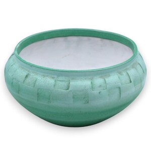 Op de afbeelding: Een ronde keramische kom met een matte mintgroene buitenkant met een herhalend reliëfpatroon van vierkanten rond het midden. De binnenkant van de kom is afgewerkt met een gladde, witte glazuurlaag, wat een contrast vormt met het textuurrijke groene oppervlak.