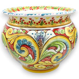 Könnte beinhalten: Ein Keramik-Pflanzgefäß mit breitem, ausgestelltem Rand und bauchigem Körper. Die Außenseite ist handbemalt mit lebhaften gelben, roten, grünen und blauen floralen Rankenmustern. Der Schriftzug Caltagirone ist im oberen Bereich des Topfes sichtbar.