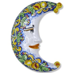 Peut inclure: Une plaque murale en forme de croissant de lune en céramique avec une finition craquelée brillante. Le visage est blanc avec des lèvres brunes et des yeux sombres. Le bord extérieur présente un motif peint à la main de grenades jaunes.