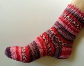 May include: A pair of striped socks in shades of pink, red, and purple. The socks are knitted and have a ribbed texture.