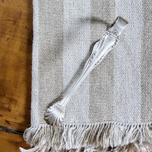 May include: A set of three ceramic mugs with a speckled, matte finish. The mugs are in shades of cream, light brown, and dark brown. Each mug has a simple, minimalist design and a rounded handle.