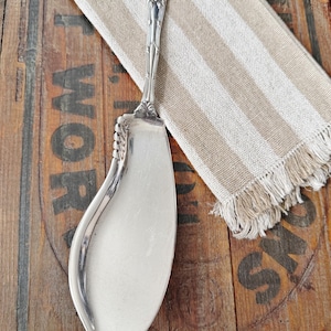 May include: A set of three ceramic mugs with a speckled, matte finish. The mugs are in shades of cream, light gray, and dark gray. Each mug has a simple, minimalist design and a rounded handle.