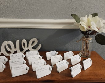 Bulk Banquet seating cards with White leather, luggage tags, for weddings, bridal or baby showers, in gold imprint & buckles