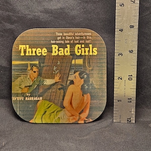 May include: A vintage paperback book cover with a yellow background and the title "Three Bad Girls" in large, bold, black letters. The cover features a woman in a green dress and a man in a suit. The text "by Evteve Harragan" is at the bottom of the cover.